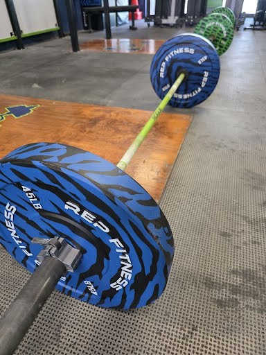 Rep Fitness bumper plates loaded on a barbell