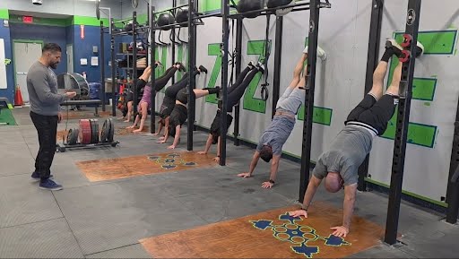 Members practicing handstand walks during class